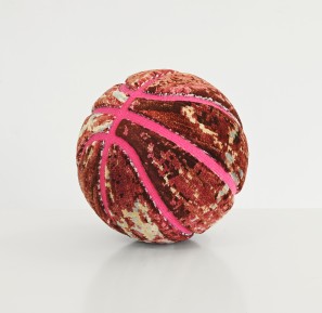 A basketball covered with colourful carpet fragments.