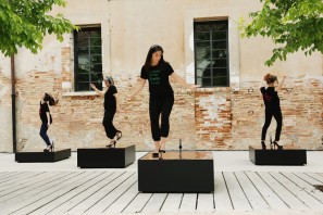Four women, wearing shoes with heels, stepping onto blocks with copper plates.