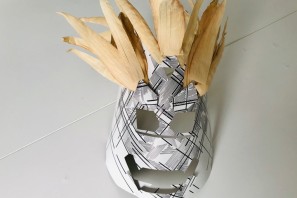 Eine selbst gebastelte Maske aus Papier und Federn.