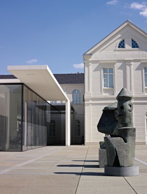 Außenaufnahme des Museums mit einer Skulptur von Max Ernst im Vordergrund