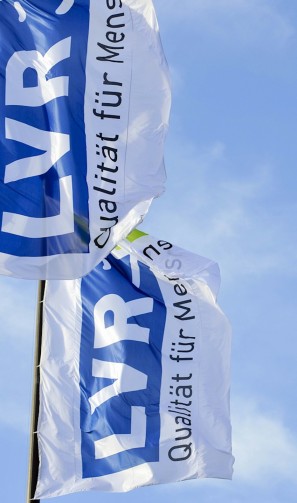 Foto: zwei Fahnen mit dem LVR Logo vor blauem Himmel