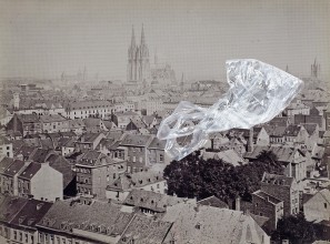 EIne schwarz-weiß Fotografie von Köln, auf der eine zerknüllte Plastiktüte liegt.