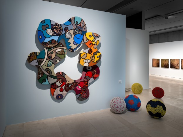 An installation view with a textile work and gymnastic balls.