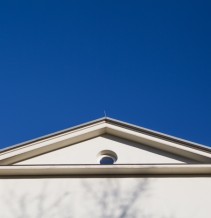 ein weißer Dachgiebel vor blauem Himmel.