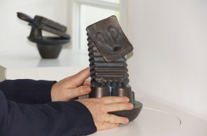 Bronzeplastik im Stil Max Ernsts wird von einer Hand abgetastet, Foto von der Taststation
