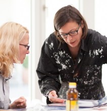Kunstvermittlerin erklärt einer Workshopteilnehmerin eine Technik von Max Ernst im Fantasie Labor