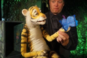 Eine Tiger-Handpuppe mit einem blauen Schmetterling