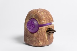 Ceramic sculpture of a bird with glass elements as eyes and beak